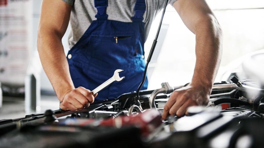 Mekaniker, der står og arbejder på en bil